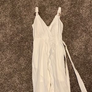White knee length dress, longer in the back, shorter in the front.